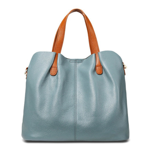 Blue handbag with brown handles on a white background