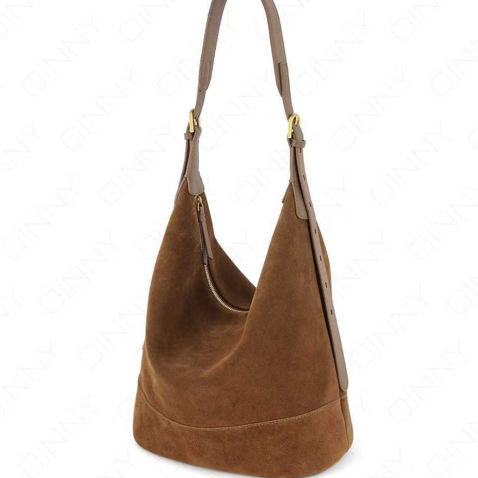 Brown suede handbag with a gold zipper on a white background