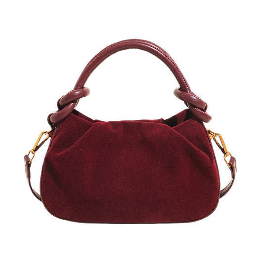 Red handbag with gold accents on a white background